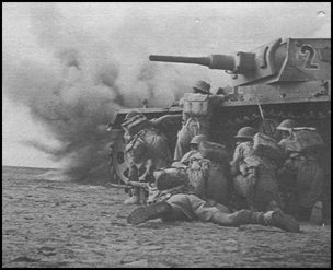 Knocked out Panzer III provides cover for British infantry